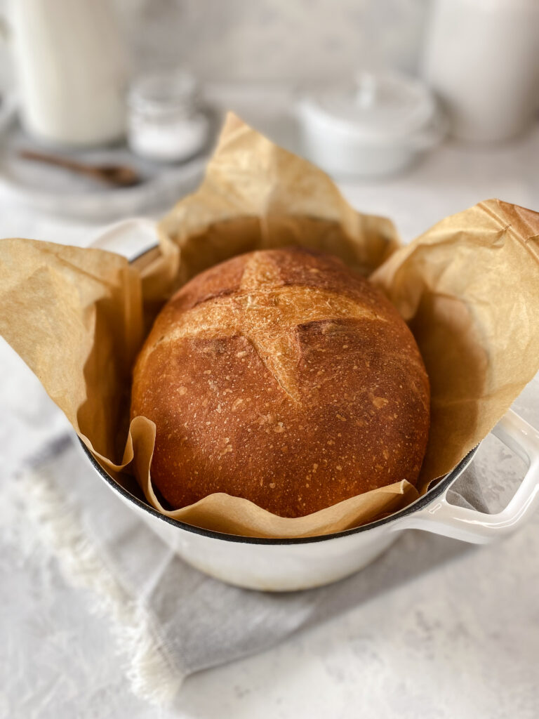 No-knead artisan bread in a white Dutch oven.