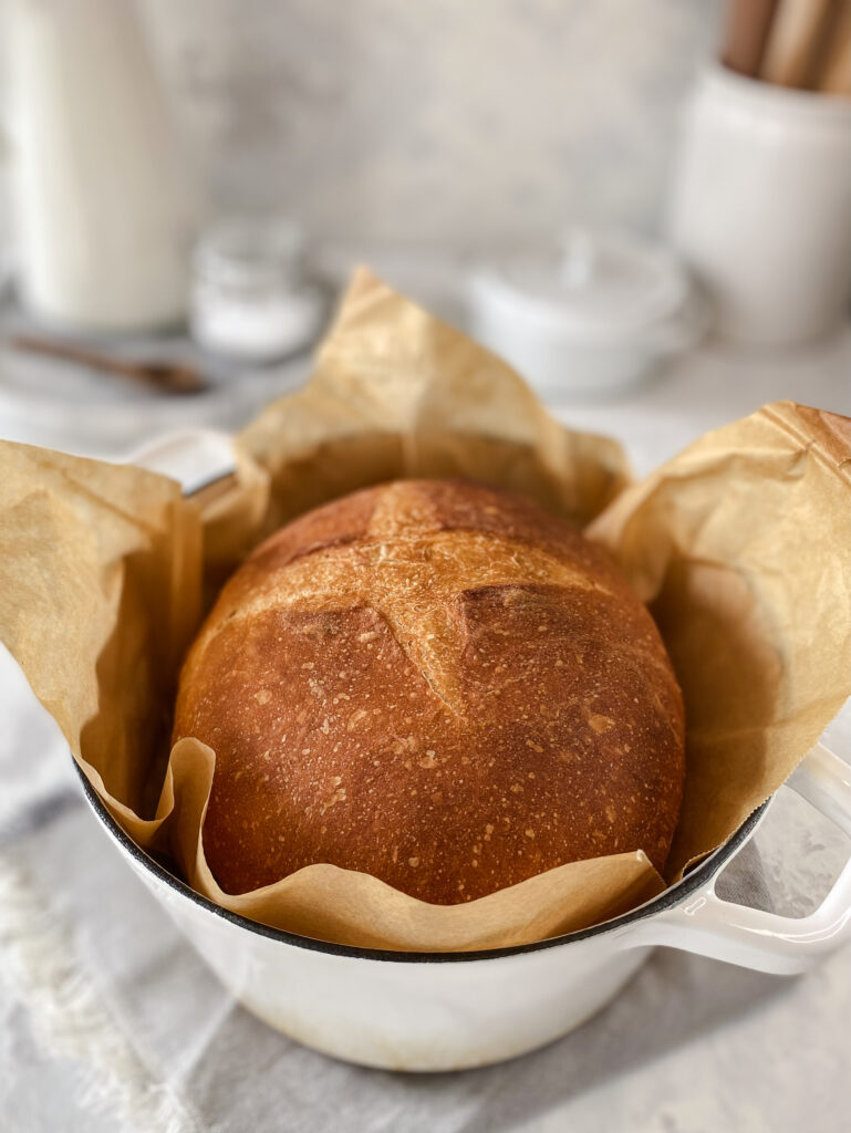 No-knead artisan bread in a white Dutch oven.