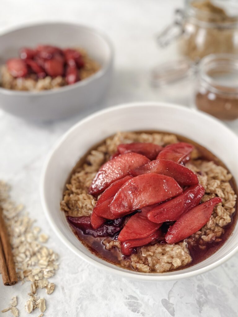 A bowl of stovetop oatmeal topped with hot buttered cinnamon apples.