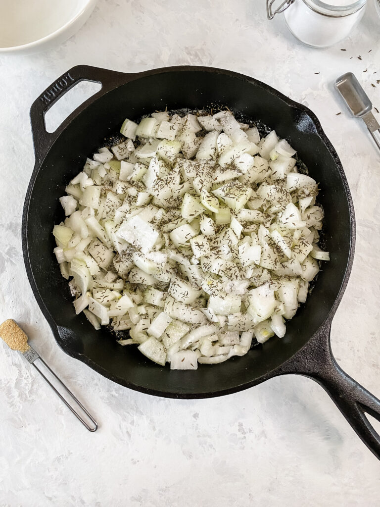 Raw onions in a cast-iron skillet with salt and thyme.