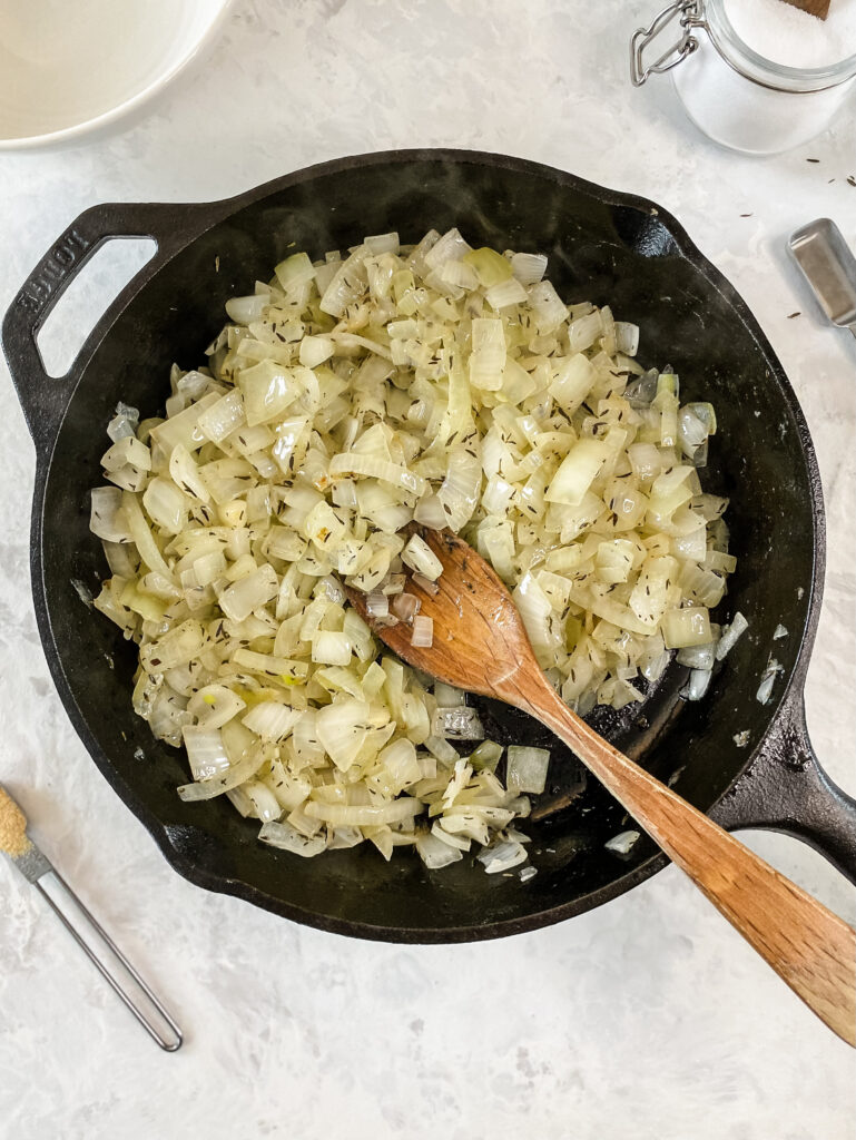 Softened onions in a cast-iron skillet.