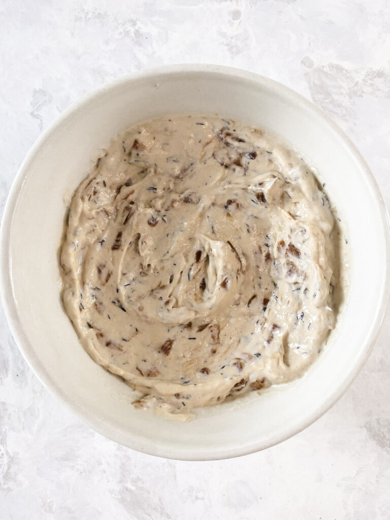 Caramelized onion dip stirred together in a white bowl.