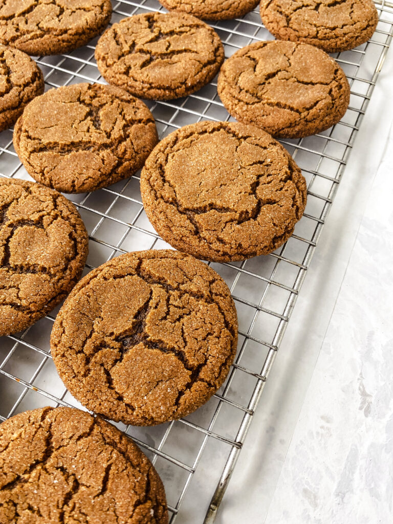 Ginger molasses crinkle cookies on a wire cooling rack.