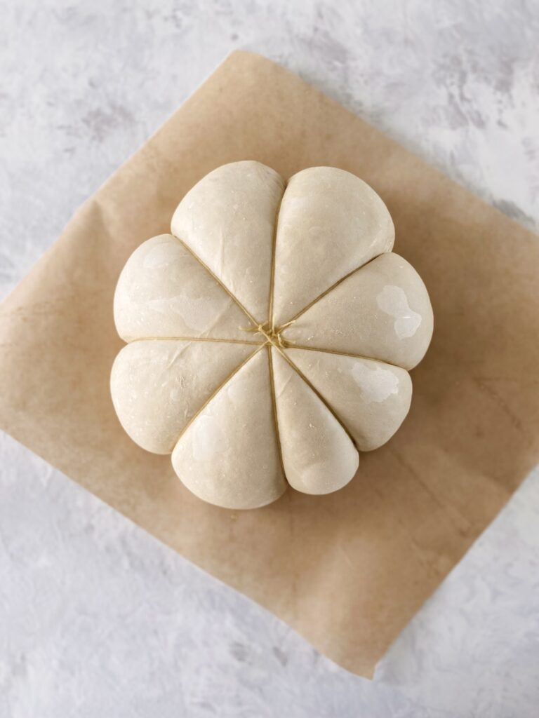 Risen, unbaked dough for pumpkin-shaped bread.