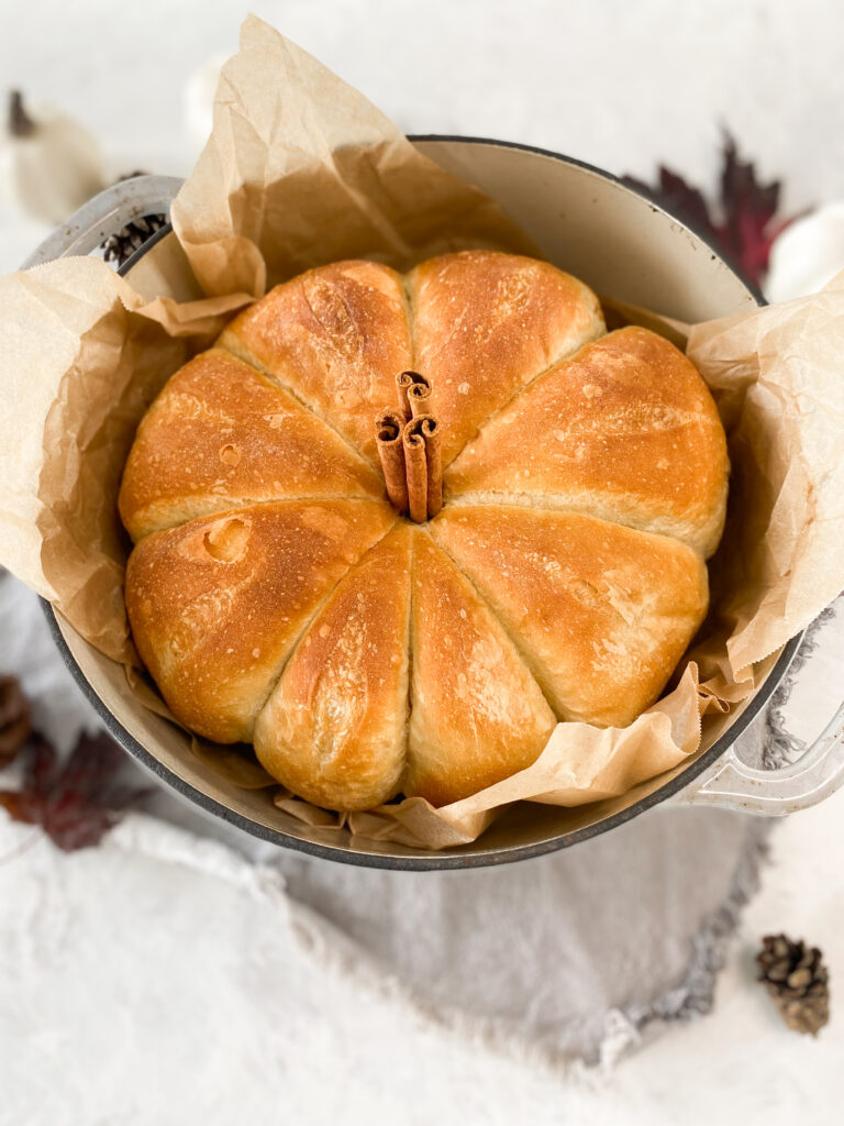 Pumpkin shaped bread in a dutch-oven with a cinnamon stick stem.