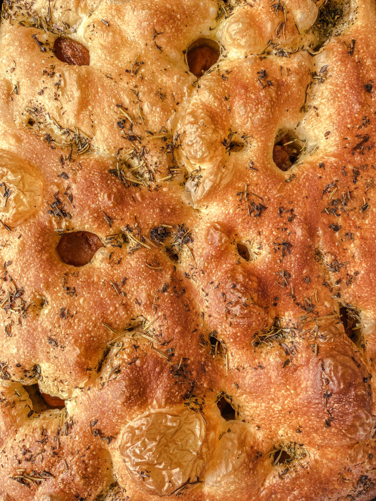 Focaccia bread topped with herbs and dimpled with roasted garlic.