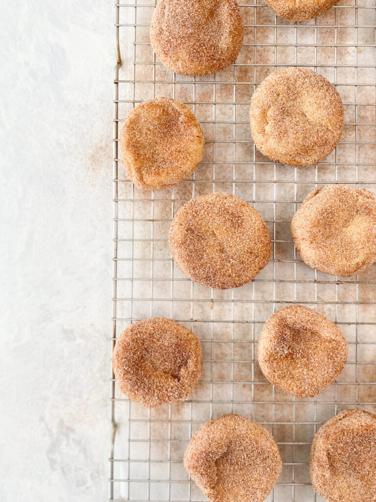 Cinnamon Snickerdoodle Cookies dusted with cinnamon sugar on a wire cooling rack.