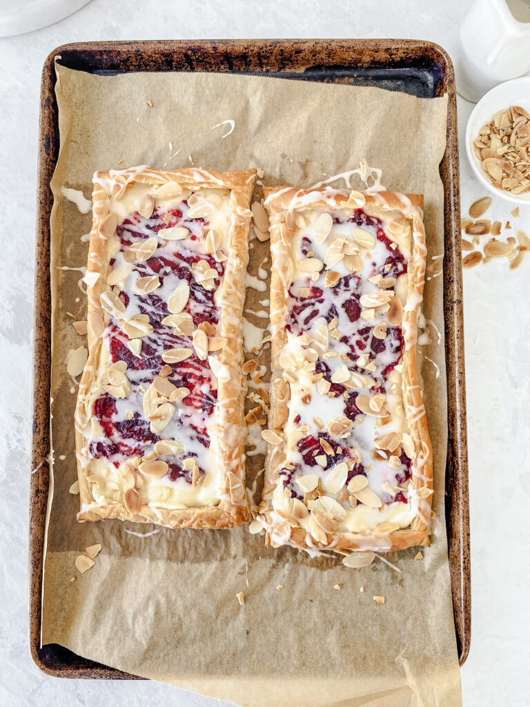 Shareable Puff Pastry Cranberry Almond Danish glazed with almond icing and topped with toasted almonds.