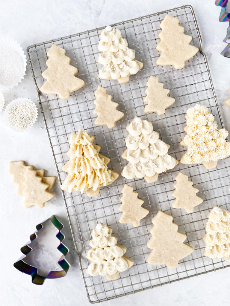 Sugar cookies frosted with buttercream on a wire cooling rack.