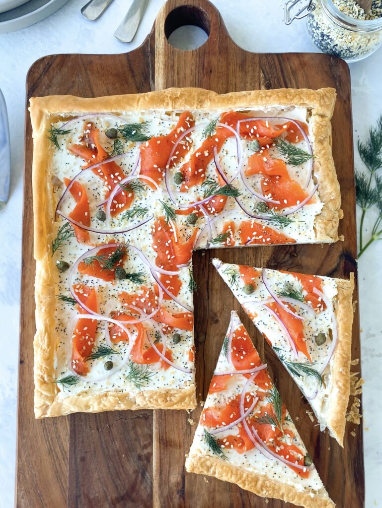 Everything Bagel Smoked Salmon Tart on a wooden cutting board.