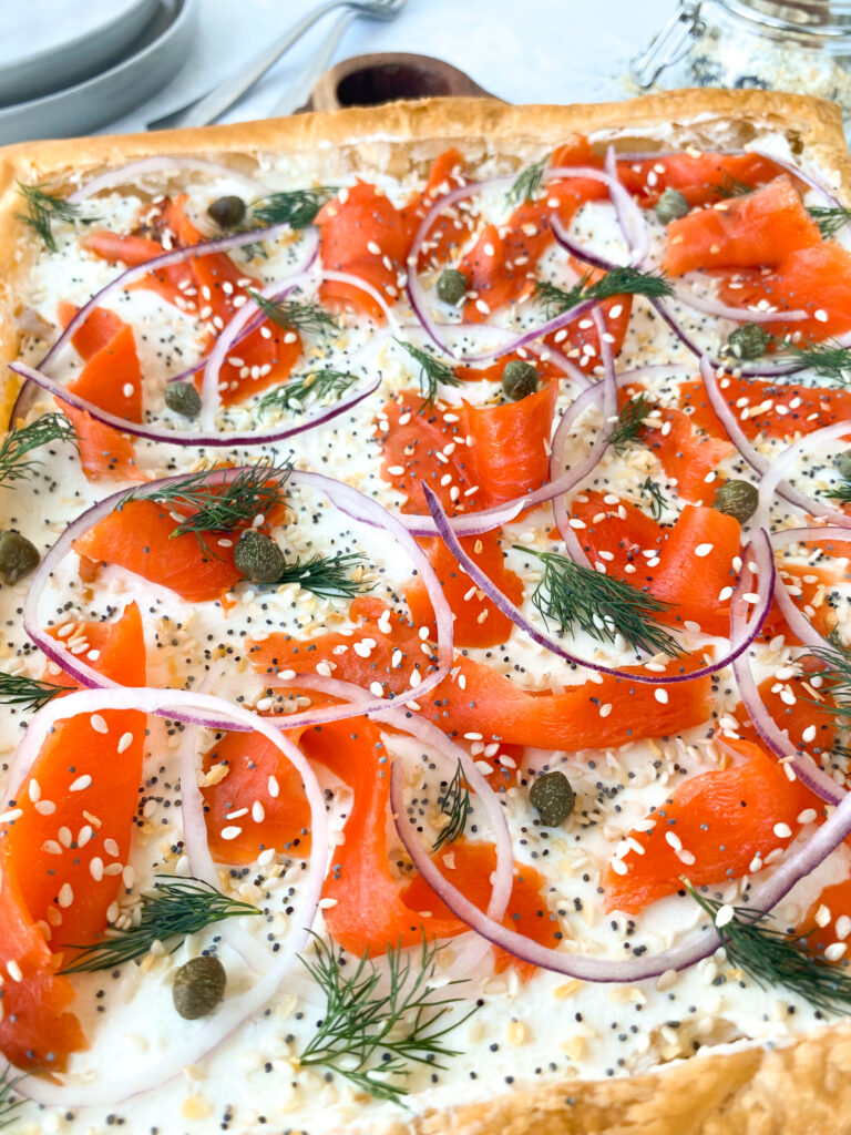 Smoked Salmon Tart on puff pastry with cream cheese, red onion, dill, capers, and everything bagel seasoning.