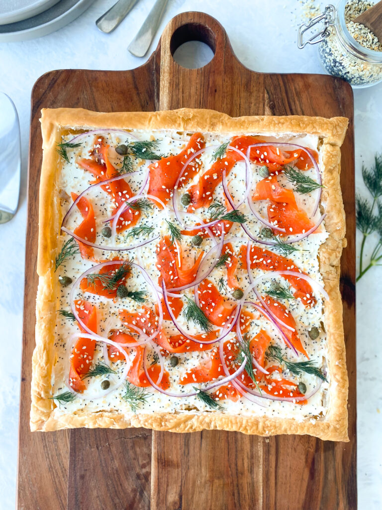 Everything Bagel Smoked Salmon Tart on a wooden cutting board.