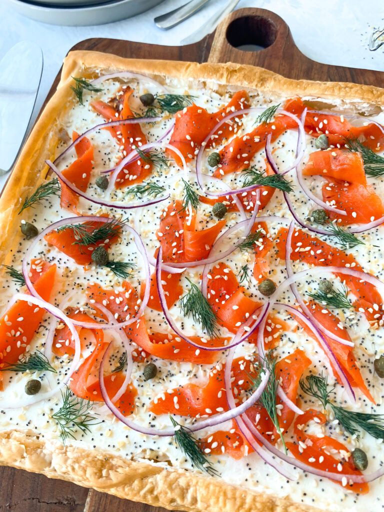 Smoked Salmon Tart on puff pastry with cream cheese, red onion, dill, capers, and everything bagel seasoning.