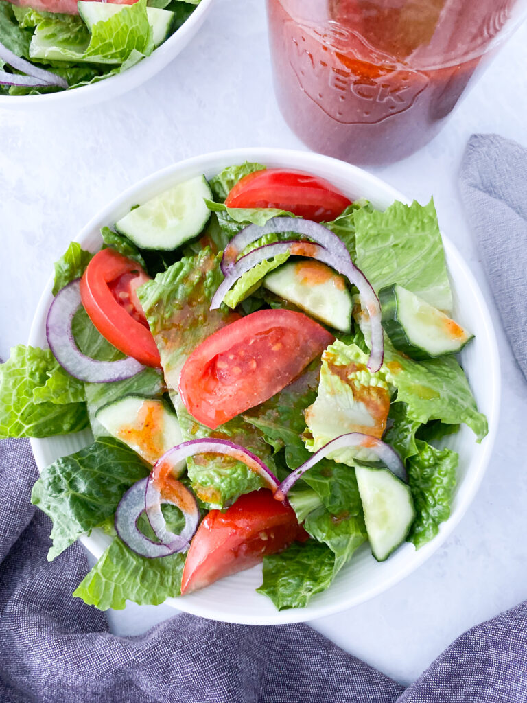 A bowl of garden salad topped with Catalina dressing.