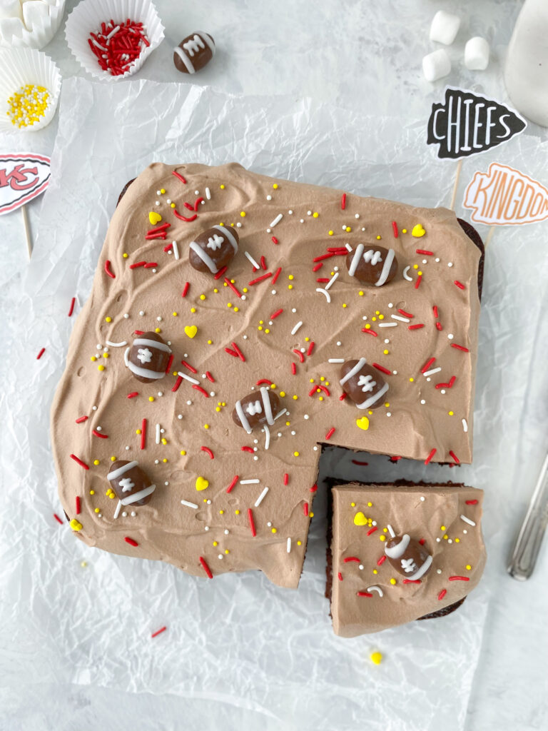 Chocolate mousse cake decorated with chocolate-covered almond footballs and sprinkles.