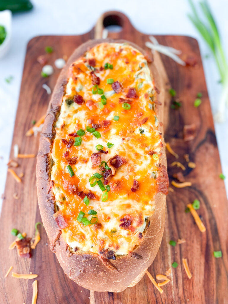 A loaf of French bread stuffed with Jalapeño Popper Dip.