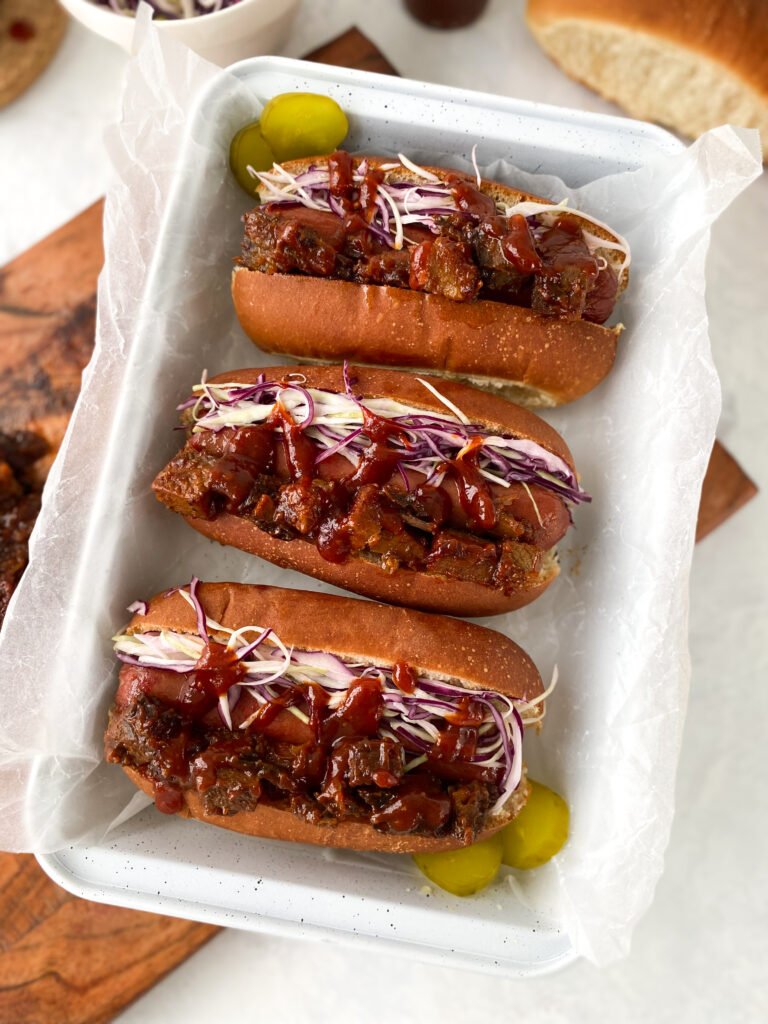 Beef hot dogs topped with brisket burnt ends, coleslaw, and sweet Kansas City barbecue sauce.