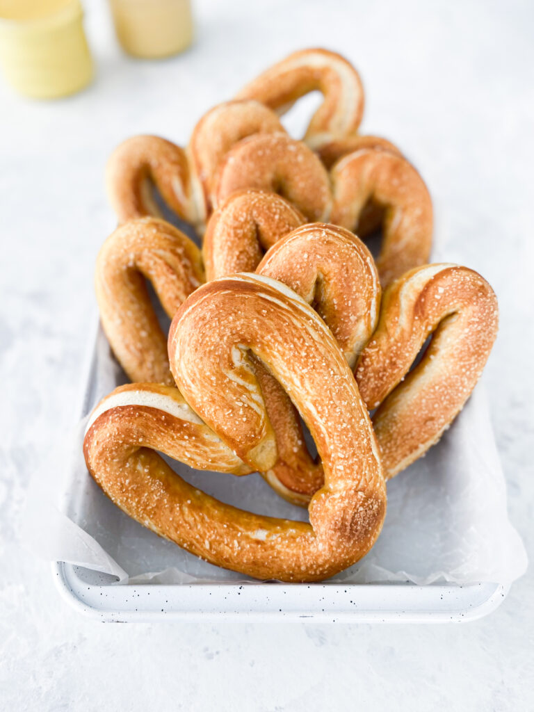 Heart shaped homemade soft pretzels with hot and honey mustard dips.