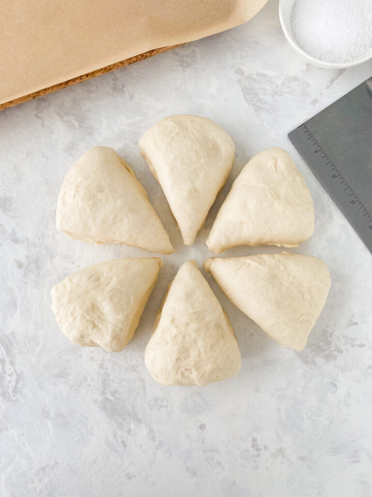 Pretzel dough divided into 6 pieces for shaping.