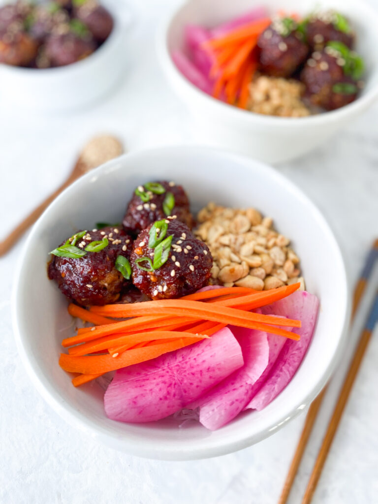 Vietnamese glass noodle bowl with spicy beef meatballs, crushed peanuts, and pickled veg.