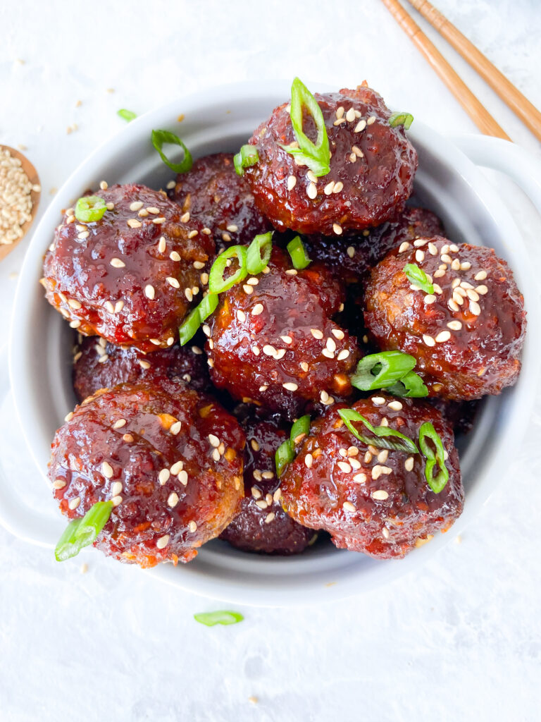 Spicy gochujang meatballs sprinkled with green onions and sesame seeds.