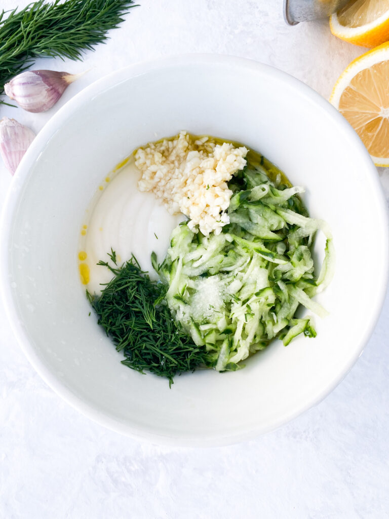 Tzatziki with Greek yogurt, grated cucumber, minced garlic, chopped dill, lemon juice, olive oil, and salt.