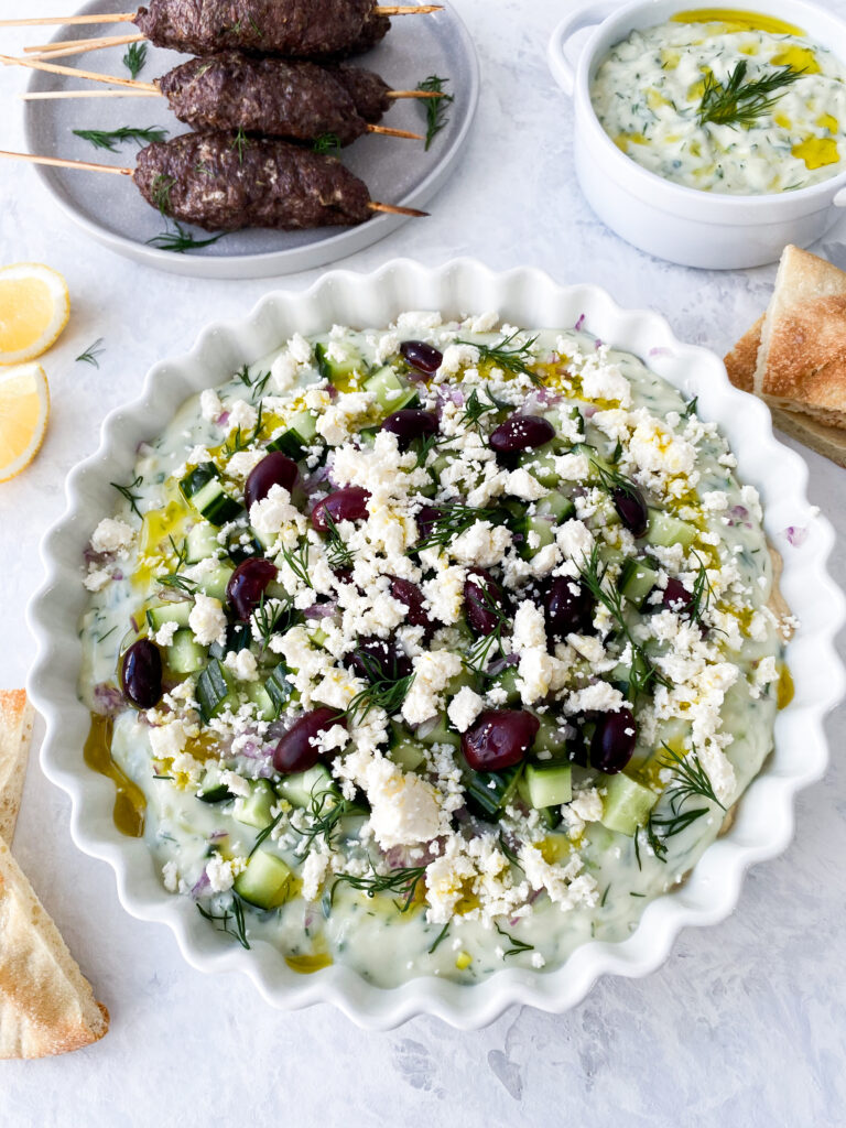 Greek layer dip with kofta kebabs, pita, and tzatziki.