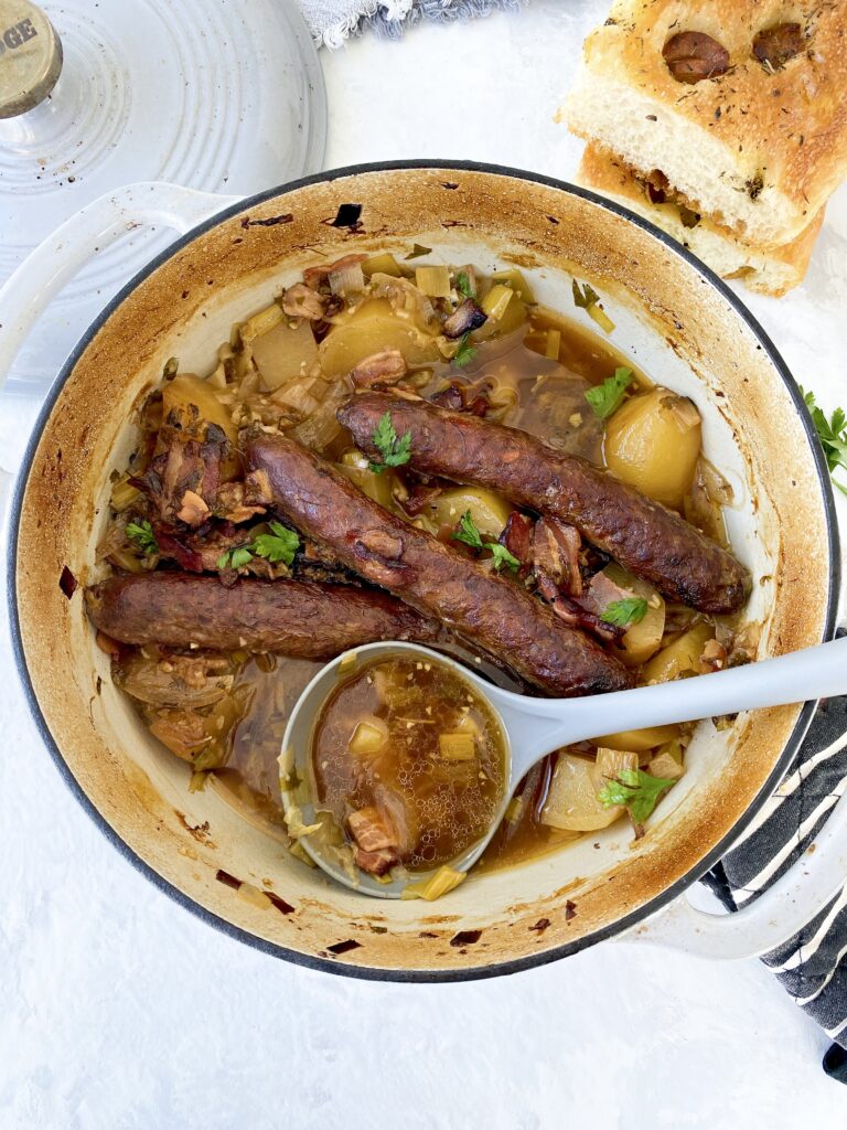 Irish sausage and potato stew (aka Dublin Coddle) being served with a ladle.