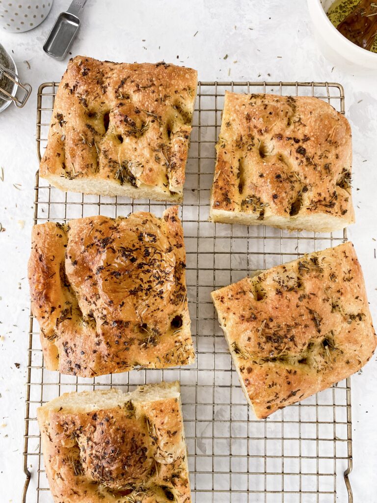 Sliced focaccia bread on a wire rack.