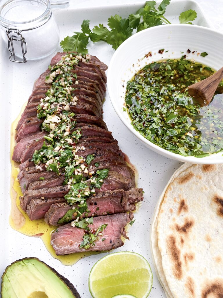 Perfectly cooked steak topped with herby chimichurri sauce
