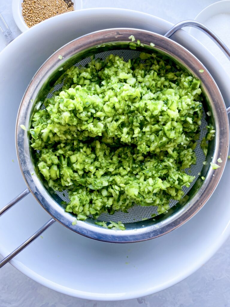 Finely chopped cucumber draining in a sieve