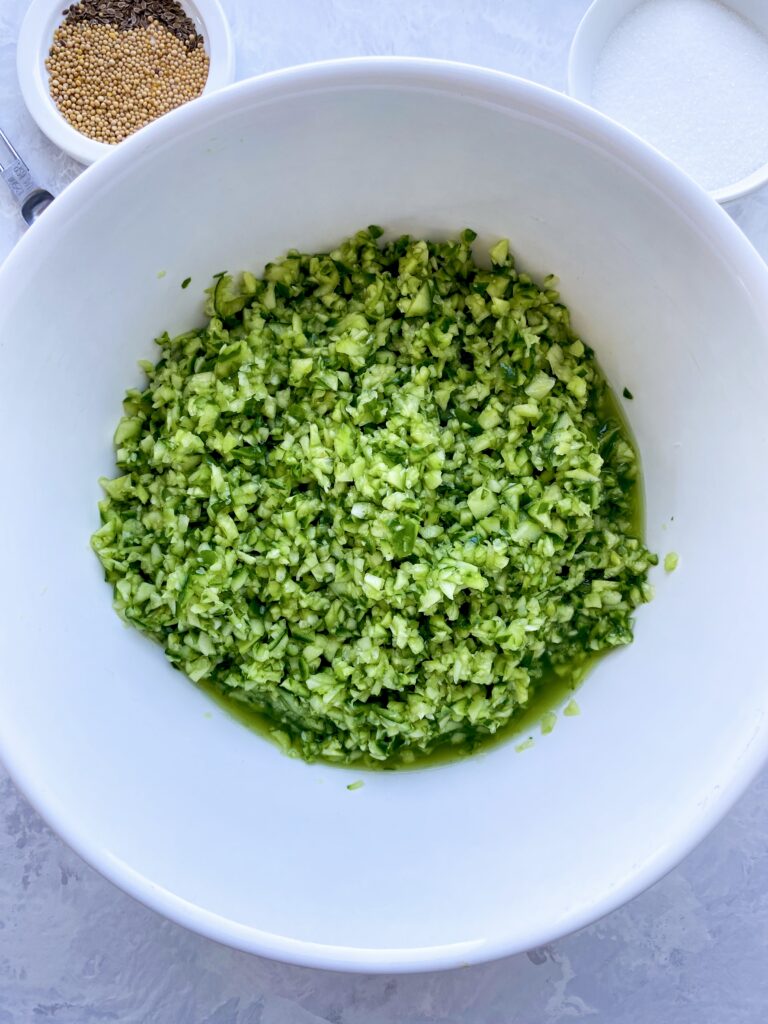Finely chopped cucumber soaking in a bowl before pickling