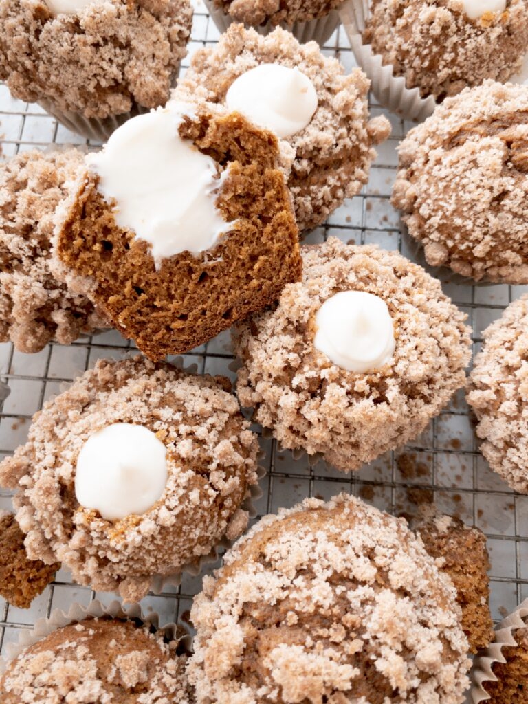 Pumpkin muffins with cream cheese filling piped in the center.