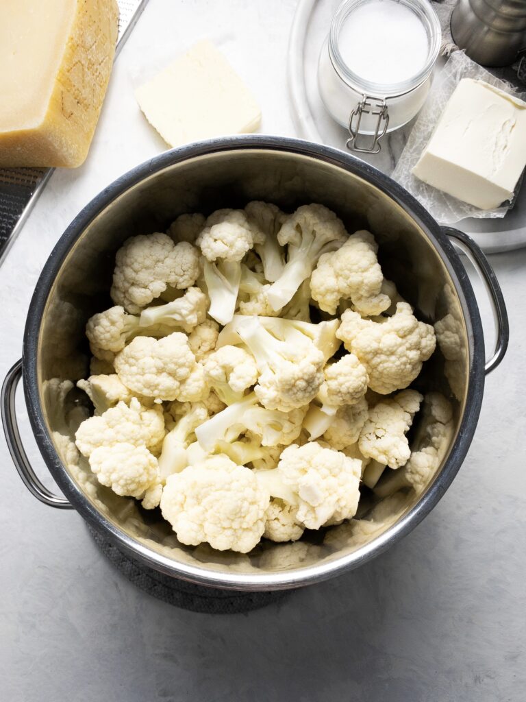 Creamy keto mashed cauliflower ingredients: cauliflower, cream cheese, butter, parmesan, and salt.