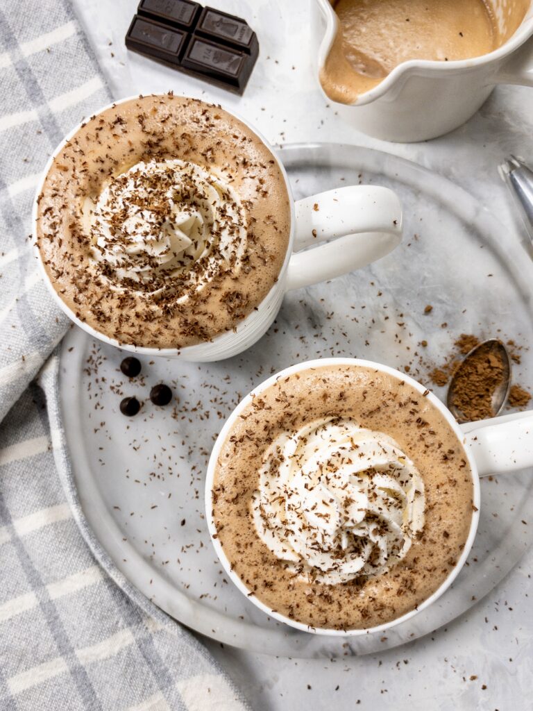Bulletproof Hot Chocolate with a swirl of whipped cream and chocolate shavings is a decadent keto dessert drink.