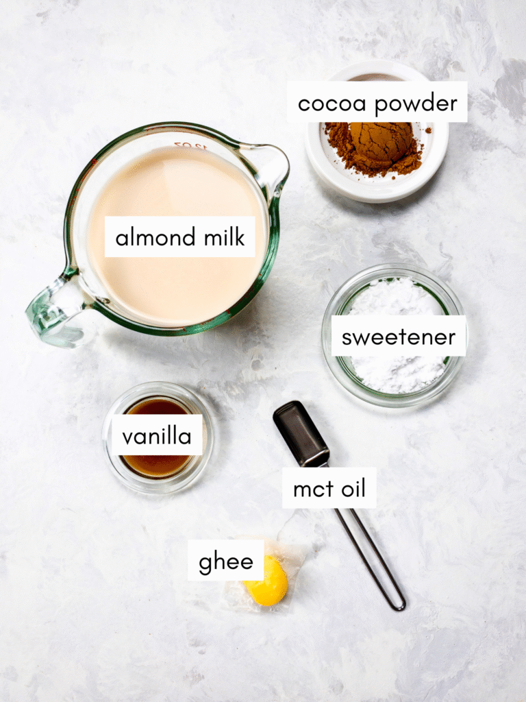 Ingredients required for Bulletproof Hot Chocolate: almond milk, cocoa powder, sugar-free powdered sweetener, ghee, MCT oil, and vanilla.
