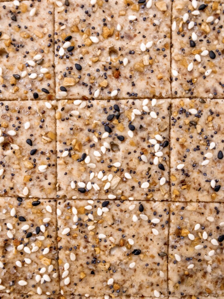 Keto Almond Flour cracker dough rolled out thin and topped with everything seasoning.