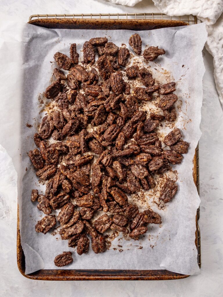 Sugar-free Candied Pecans resting on the baking sheet while they cool and crisp up.