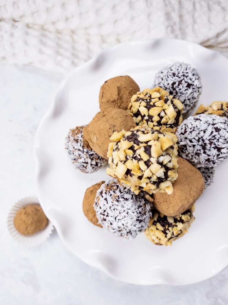 Dark Chocolate Truffles rolled in cocoa powder, shredded coconut, and crushed peanuts for an easy keto-friendly dessert.