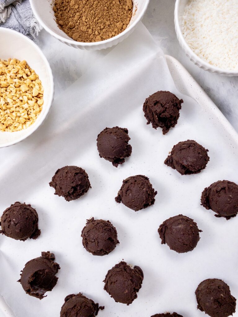Chocolate ganache truffles on a parchment-lined baking sheet.