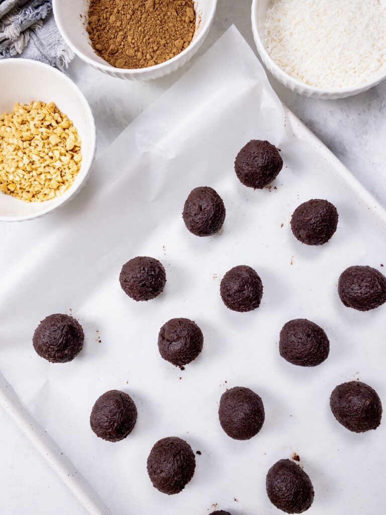 Chocolate ganache truffles on a parchment-lined baking sheet.