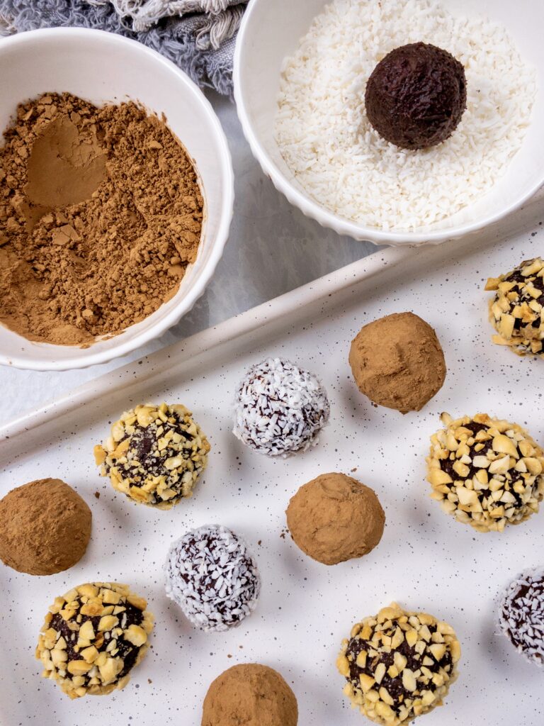 Truffles coated in an assortment of shredded coconut, cocoa powder, and chopped nuts.