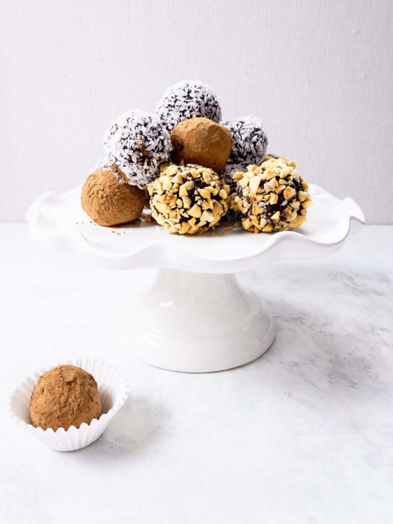 Keto Chocolate Truffles rolled in cocoa powder, shredded coconut, and crushed peanuts for an easy holiday dessert.