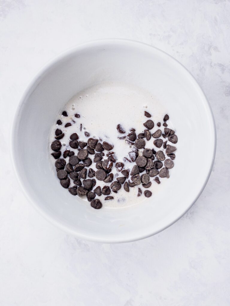 Hot coconut cream poured over sugar-free dark chocolate chips for ganache truffles.