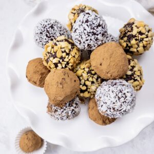 Dark Chocolate Truffles rolled in cocoa powder, shredded coconut, and crushed peanuts for an easy keto-friendly dessert.