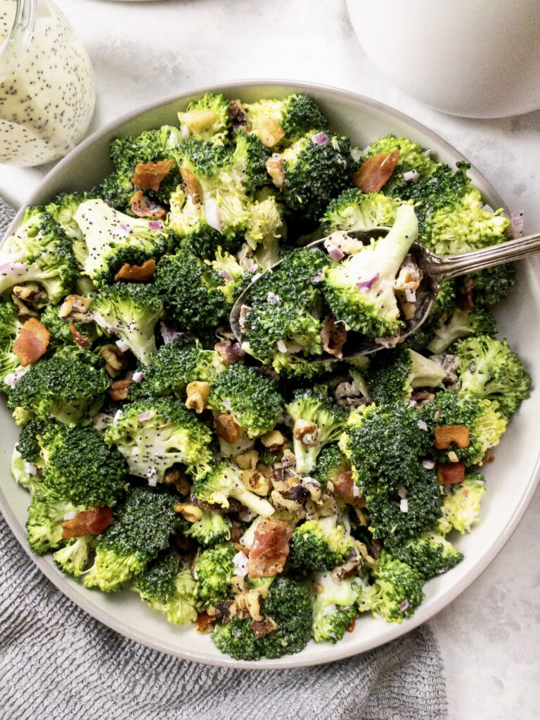 Fresh broccoli florets topped with crumbled bacon, chopped walnuts, diced red onion, and simple poppy seed dressing make a delicious keto-friendly salad.