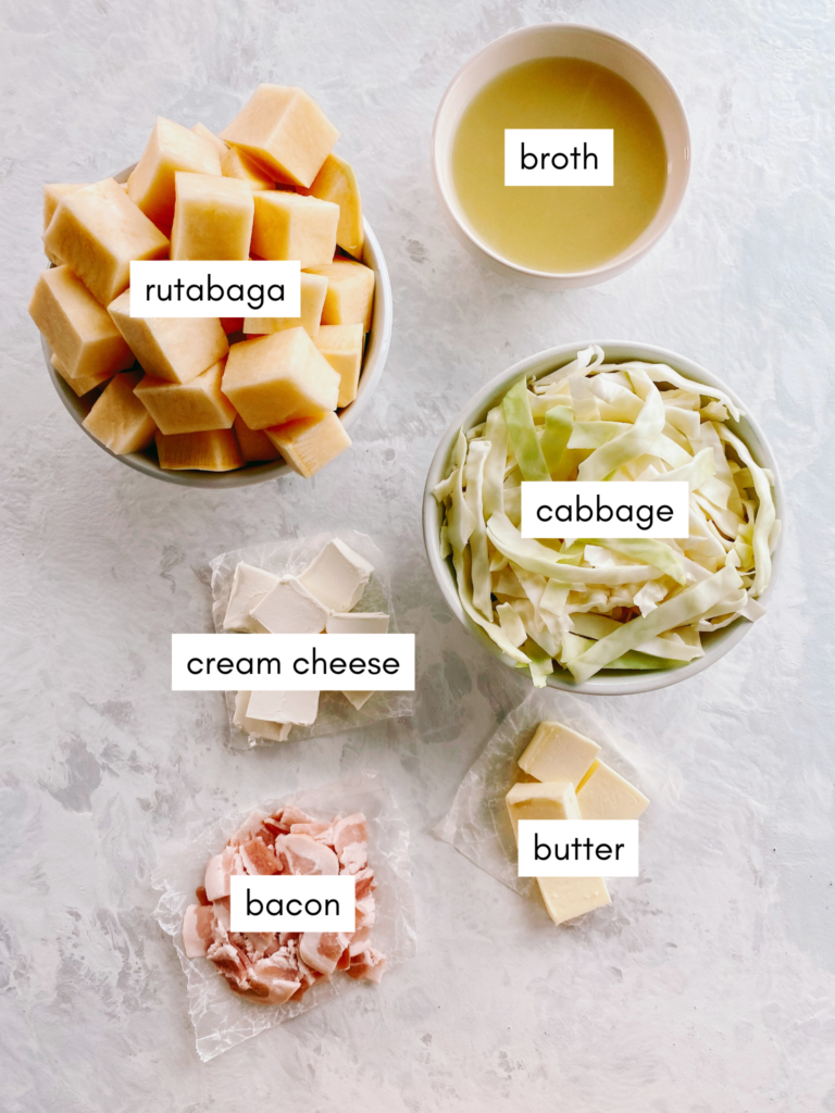 Ingredients needed for low-carb Colcannon: rutabaga, green cabbage, chicken broth, cream cheese, butter, and bacon.