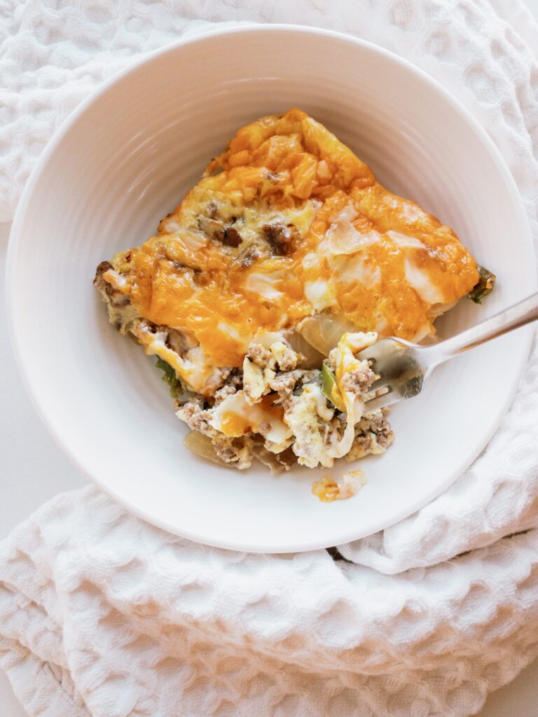 Keto-friendly egg casserole made with sausage, onion, poblano pepper, and a blend of mozzarella + cheddar cheese.